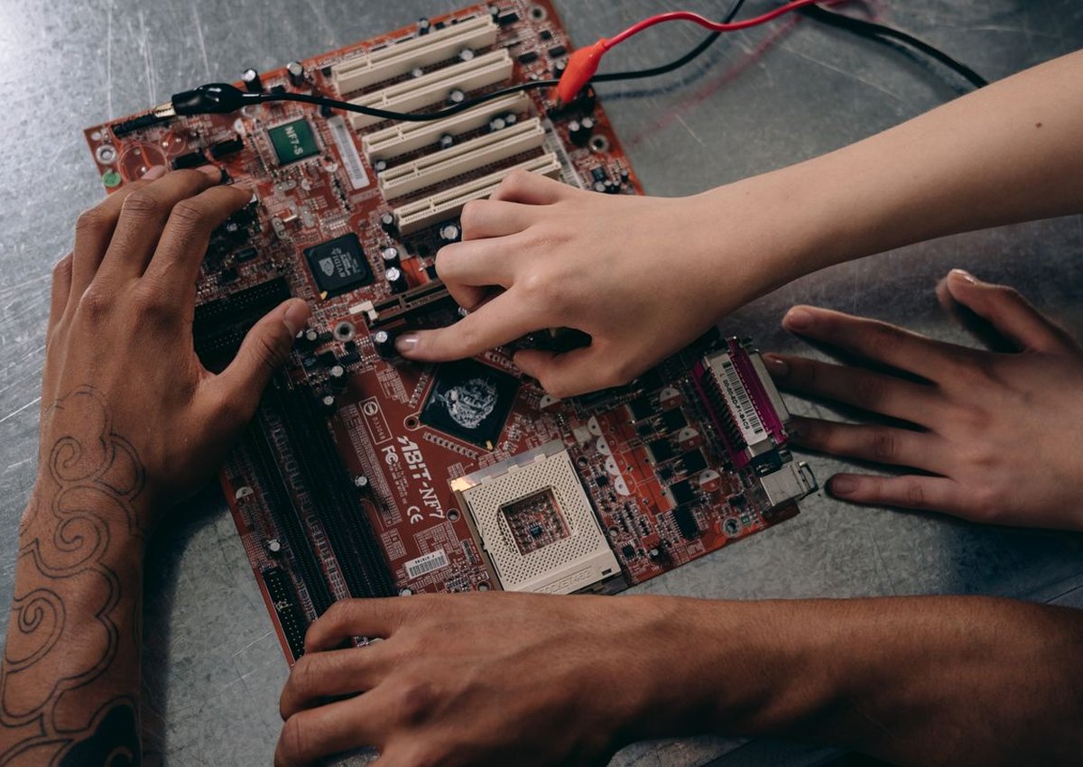 Técnico manuseando uma placa-mãe de computador sobre uma bancada