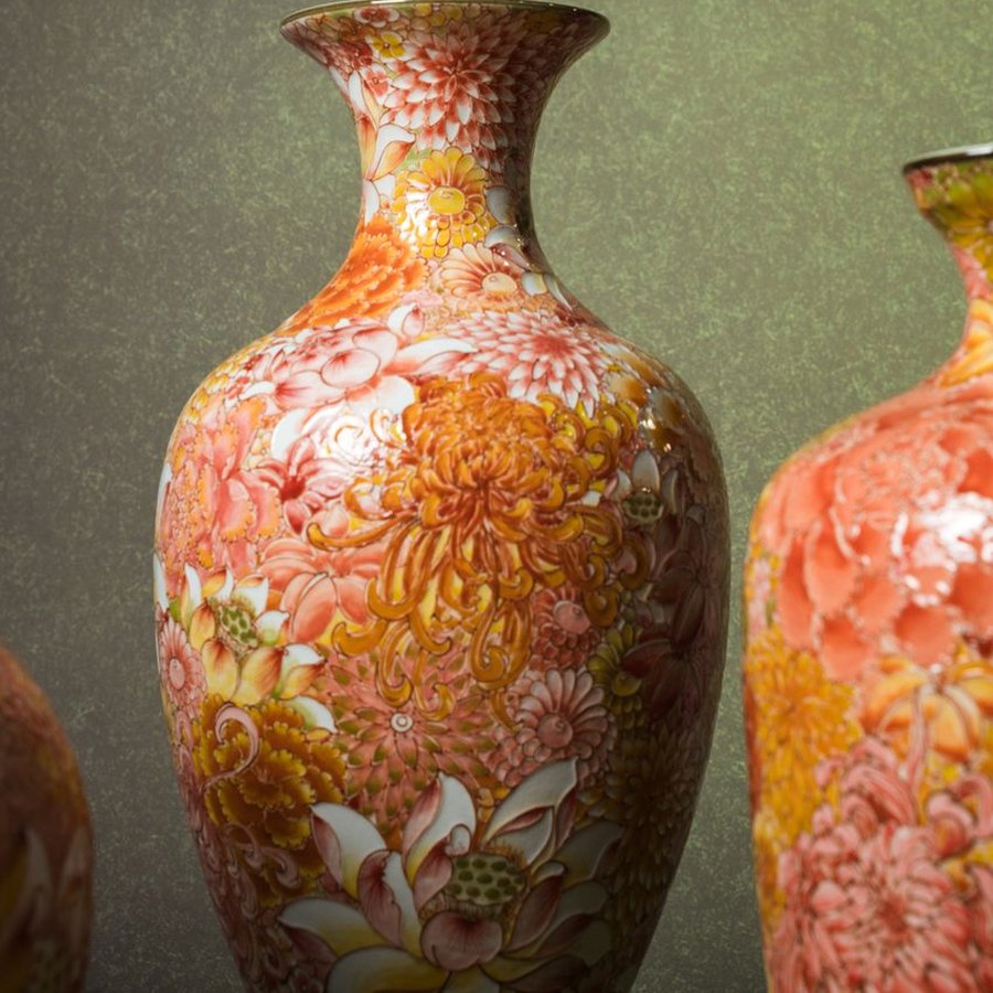 Vasos floridos em cerâmica sendo preenchidos com água