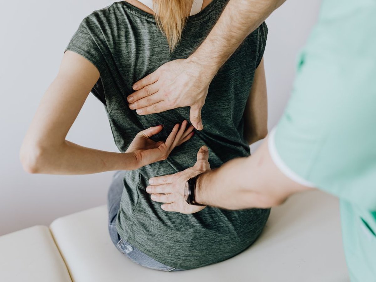 Mãos da fisioterapeuta durante a avaliação do movimento de uma paciente